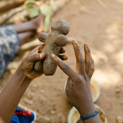 A mother makes a toy from clay during a children’s toy making workshop in her community in Balaka district, Malawi.