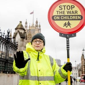 Volunteer poses as a Crossing Guard for a Gaza social media stunt in front of  Westminster for 2025 brand campaign  ‘Lasting change starts here’