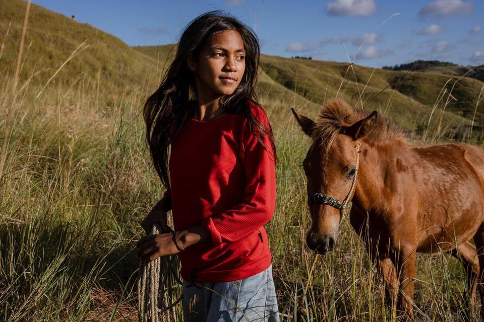 Atika, 12, walking a neighbour’s horse up the valley in drought-affected East Sumba, Indonesia.